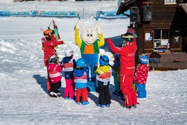 Een groep kleine kinderen vermaakt zich in de sneeuw tijdens de kinderskilessen Bambini voor beginners met de Grindelwald Skischool.