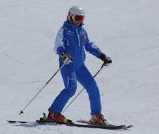 Maestro di sci che mostra lo spazzaneve durante una delle lezioni di sci per adulti per principianti ad Andalo.