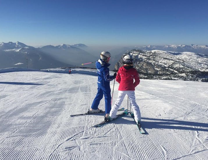 Un moniteur de ski enseignant à un participant à Andalo pendant l'un des cours de ski pour adultes pour débutants.