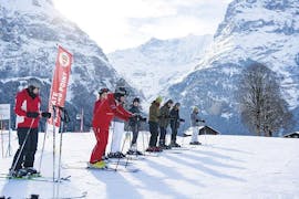 Un gruppo di sciatori aspetta in pista durante le lezioni di sci per bambini di livello intermedio della Swiss Ski School di Grindelwald.