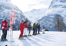 Een groep skiërs wacht op de piste tijdens hun kinderskilessen voor halfgevorderden bij de Grindelwald-skischool.