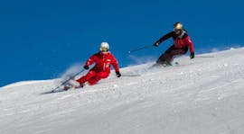 Uno sciatore adulto segue il suo istruttore durante le lezioni private di sci per adulti per tutti i livelli della Swiss Ski School Grindelwald.