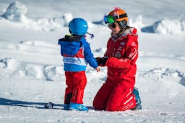 Un maestro di sci della Swiss Ski School Grindelwald si occupa amorevolmente di un piccolo sciatore durante una lezione privata di sci per bambini di tutti i livelli.
