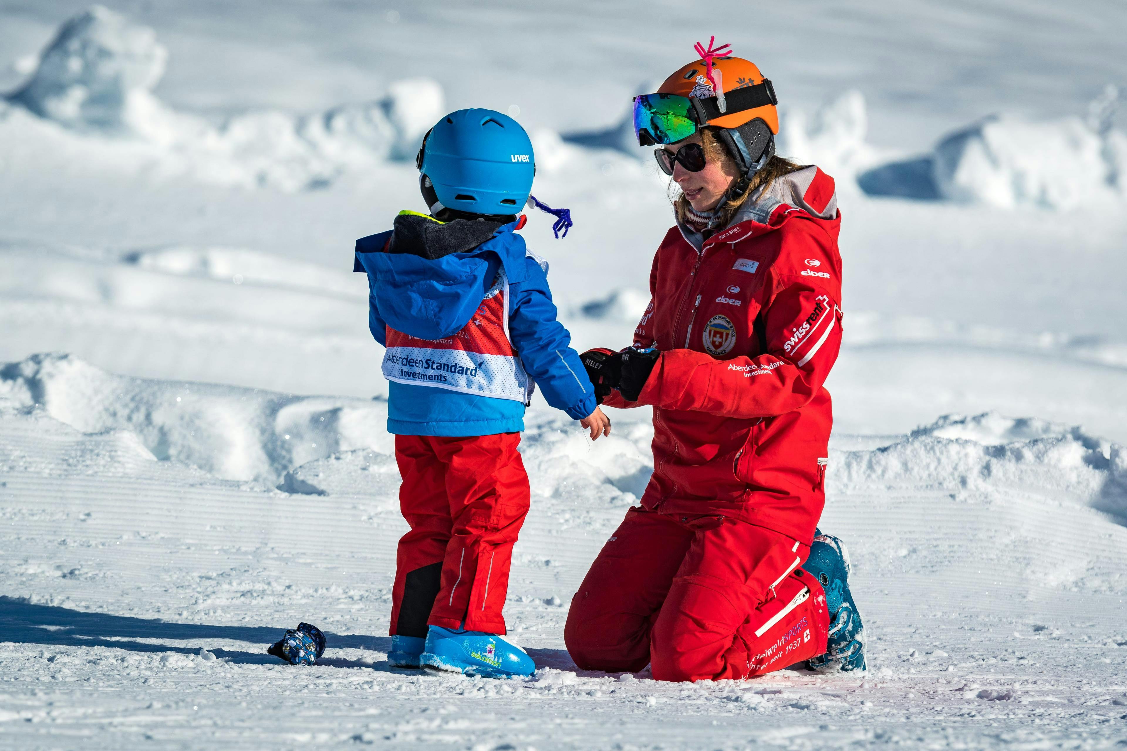 Private Ski Lessons for Kids (3-15 y.) of All Levels from Swiss Ski School Grindelwald A ski instructor from the Swiss Ski School Grindelwald lovingly looks after a little skier during a private kids ski lessons for all levels.