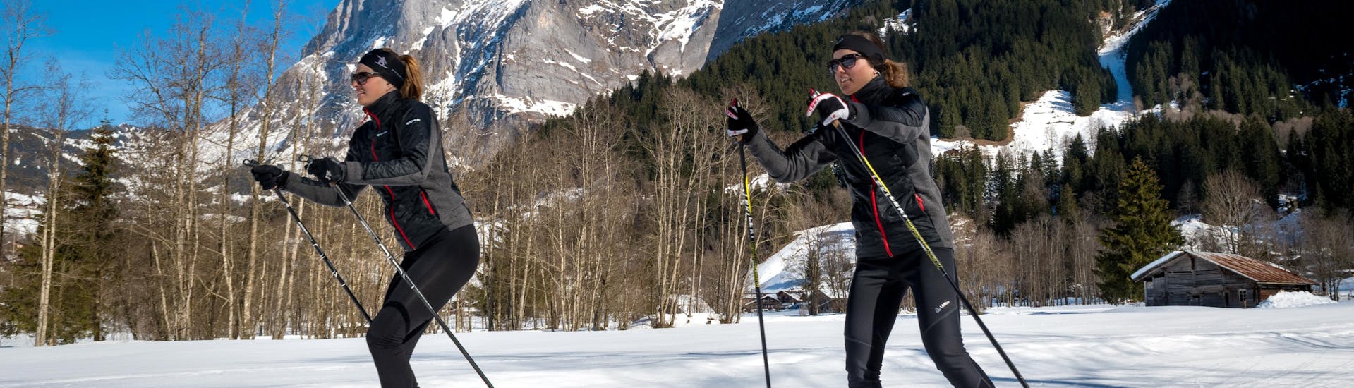 Due fondisti si godono l'aria fresca durante il corso privato di sci di fondo per tutti i livelli con la Swiss Ski School Grindelwald.
