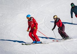Een groep gevorderde skiërs volgt hun instructeur tijdens hun volwassen skilessen voor gevorderde skiërs bij de Zwitserse skischool Grindelwald.
