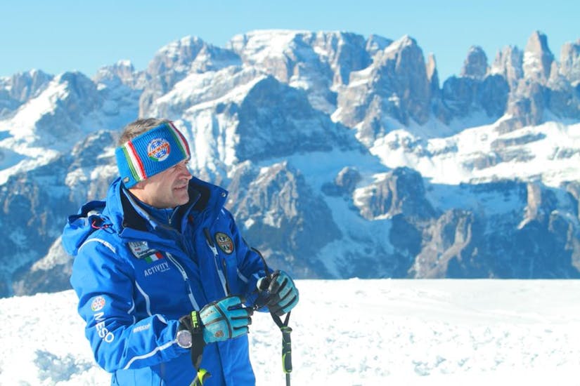 Maestro di sci davanti alle montagne di Andalo durante una delle Lezioni di Sci per Adulti per sciatori avanzati.