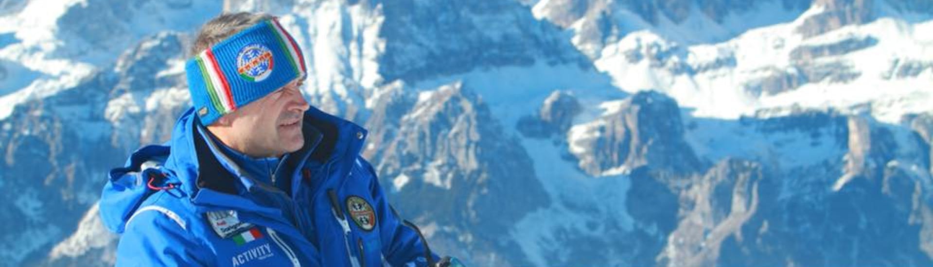 Skileraar met bergen van Andalo op de achtergrond voor een van de Skilessen voor Volwassenen voor Gevorderde Skiërs.