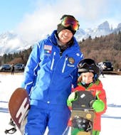 Kid and snowboard instructor in Andalo after one of the Snowboarding Lessons for Kids & Adults of All Levels.