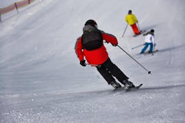 Partecipante segue il maestro di sci ad Andalo durante una delle Lezioni Private di Sci per adulti di tutti i livelli. 