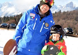 Kid and snowboard instructor in Andalo during one of the Private Snowboarding Lessons for Kids & Adults of All Levels.