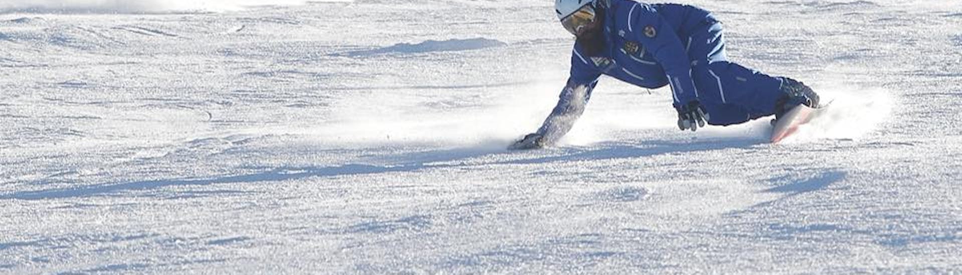 Maestro di snowboard sulle piste di Andalo si allena per una delle Lezioni private di snowboard per bambini e adulti.