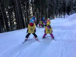 Bambini che frequentano il loro primo corso di sci durante una delle lezioni di sci per principianti a Cavalese.