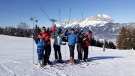 A group of skiers smiling during their Private Ski Lessons for Kids for Advanced Skiers from Ski School Ski Total Kirchdorf.