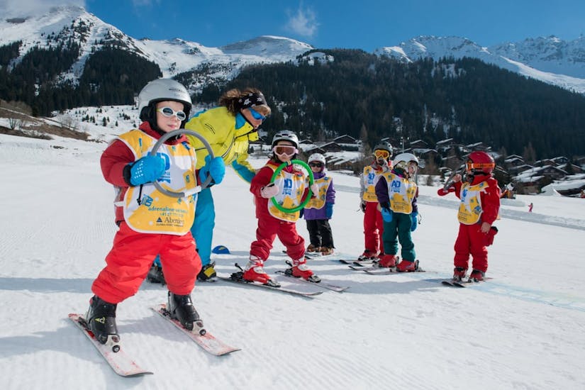 Children warming up during their kids ski lessons from 3 to 5 years 6 Max with Adrenaline Verbier.