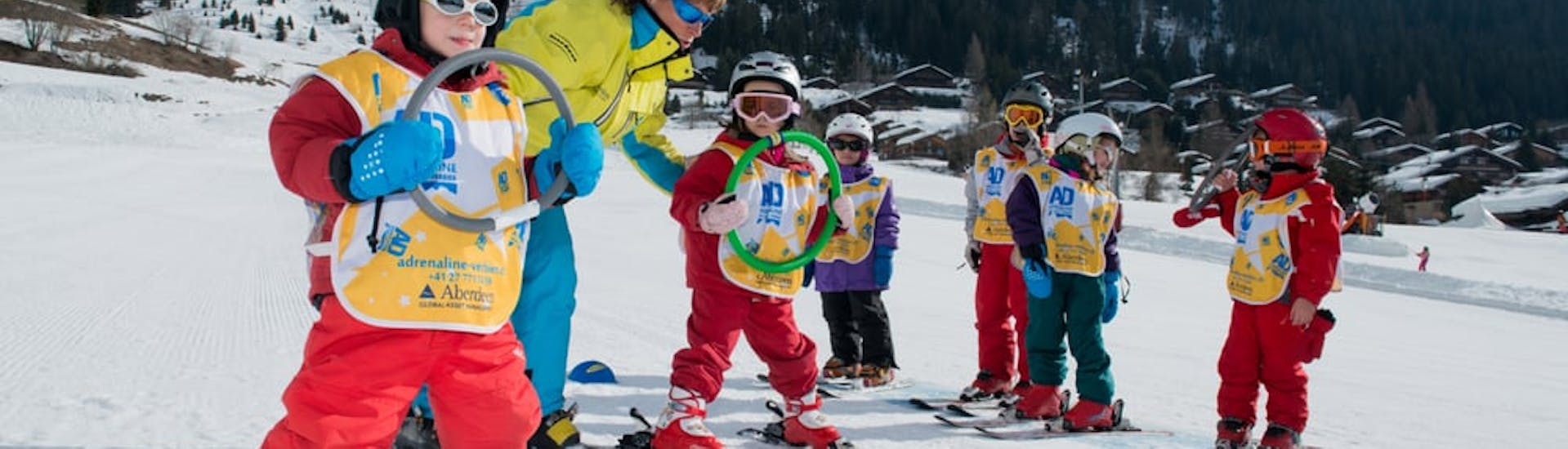 Children warming up during their kids ski lessons from 3 to 5 years 6 Max with Adrenaline Verbier. 