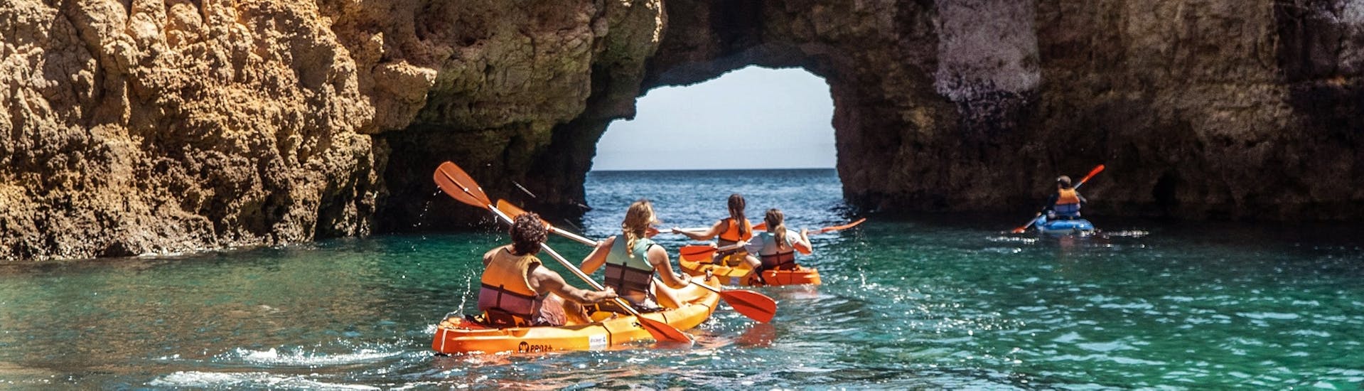 Eine Gruppe von Freunden paddelt während einer Seekajaktour zu den Grotten von Ponta da Piedade mit Discover Tours Lagos.