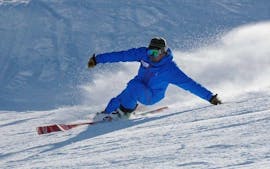 A Ski Connections instructor shows during a private ski lesson for adults how to make beautiful parallel turns on a slope in Serre-Chevalier.