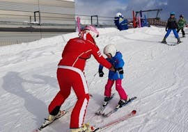 A ski instructor teaches a kid during a Kids Ski Lessons "Miniclub" (2-6 y.) in Campo Tures - Sand in Taufers. 