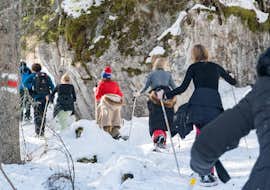 Alpines Winterabenteuer mit Schneeschuhtour und Rodeln mit Outdoor Switzerland AG Eine Gruppe Menschen stapft bei ihrem Alpinen Winterabenteuer mit Schneeschuhtour und Rodeln durch den Tiefschnee.