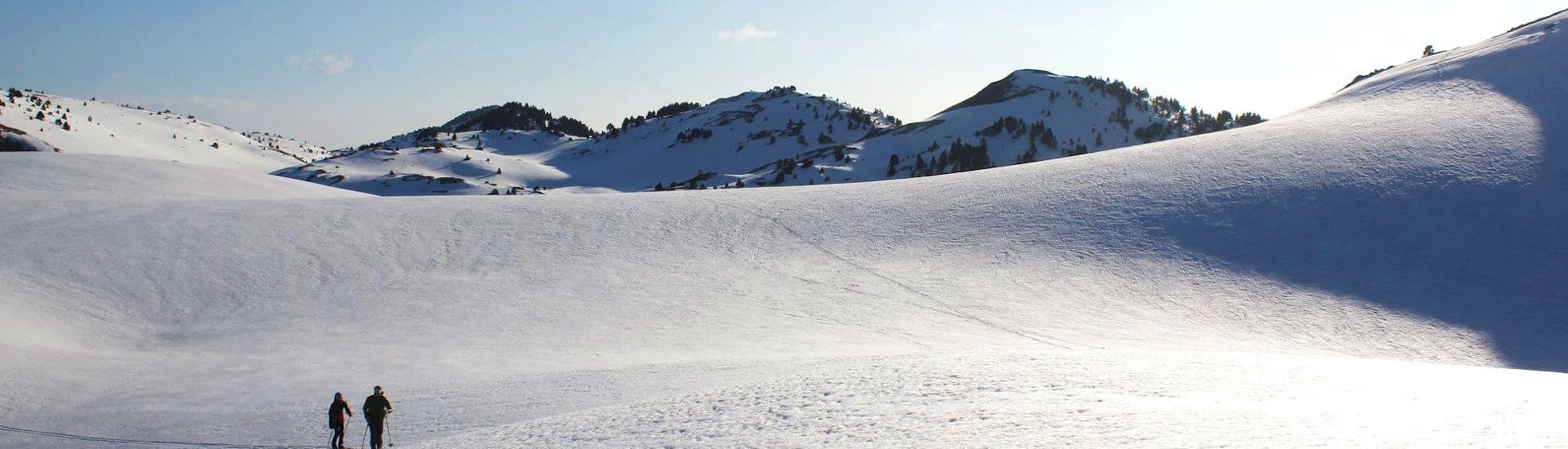 Des skieurs font du ski de fond au milieu d'un paysage enneigé pendant leur Cours de ski de fond en Famille - Tous niveaux avec l'école de ski ESI La Boîte à montagne.