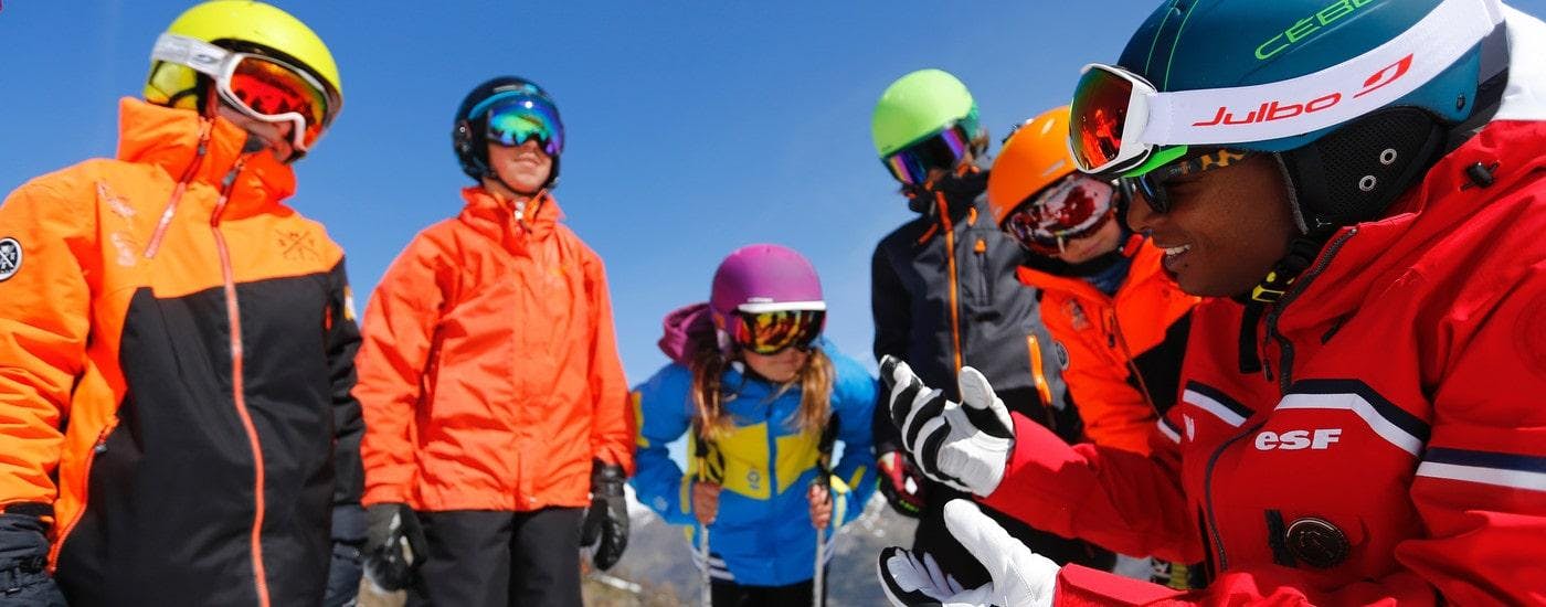 Teens are gathered around their ski instructor from the ski school ESF Alpe d'Huez before their Ski Lessons for Teens "Team Rider" (13-17 y.) - All Levels.