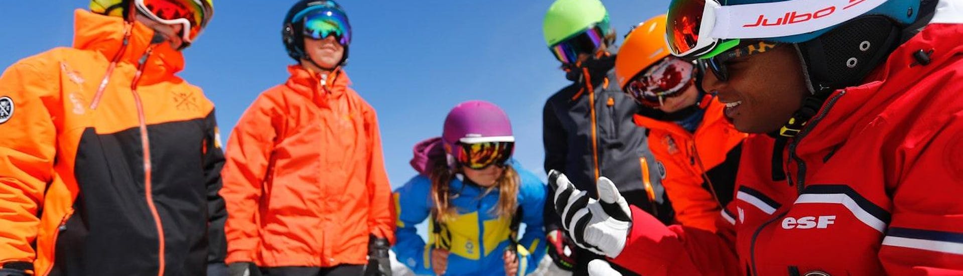 Los adolescentes se reúnen alrededor de su instructor de esquí de la escuela de esquí ESF Alpe d'Huez, antes de sus clases de esquí para adolescentes "Team Rider" (13-17 años) - Todos los niveles.