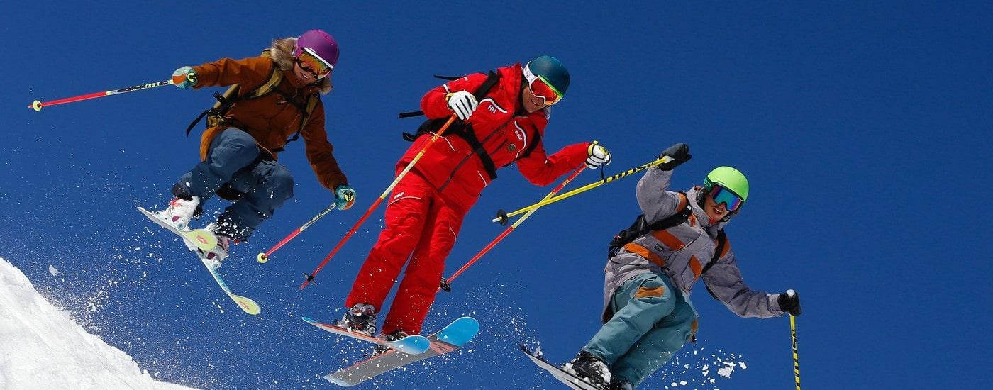 Des skieurs skient avec assurance avec leur moniteur de ski de l'école de ski ESF Alpe d'Huez pendant leur Cours de ski pour Adultes - Tous niveaux.