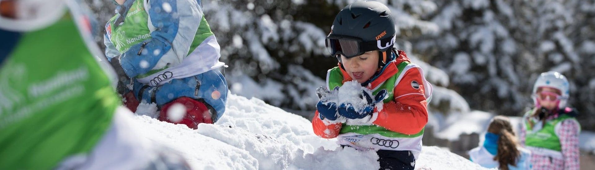 Kids are playing in the snow during Kids Ski Lessons (2-4 years) - First Timer organized by the Carezza Skischool.