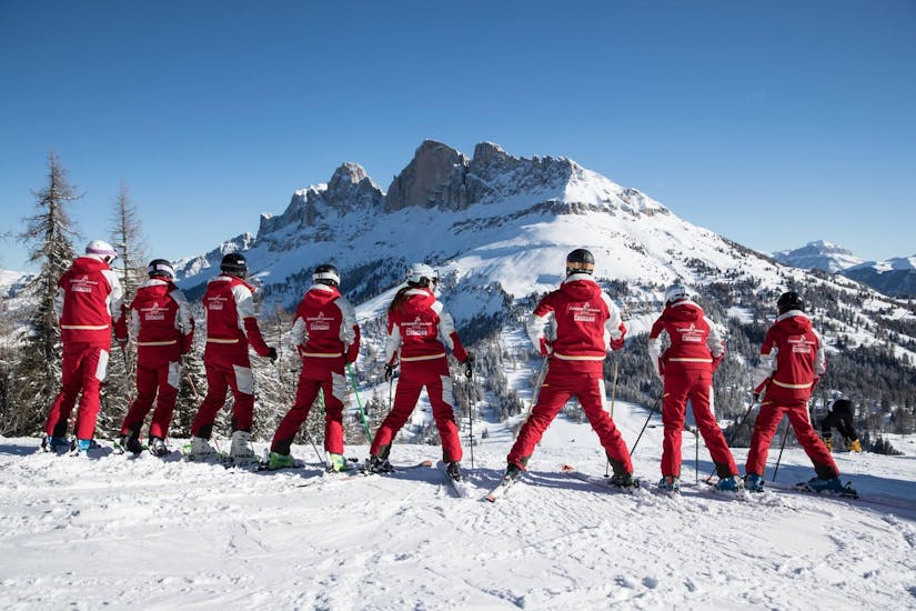 A group of adults is looking at the Dolomites during Ski Lessons for Adults - Beginner from the Carezza Skischool.
