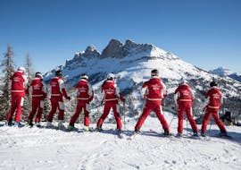 A group of adults is looking at the Dolomites during Ski Lessons for Adults - Beginner from the Carezza Skischool.