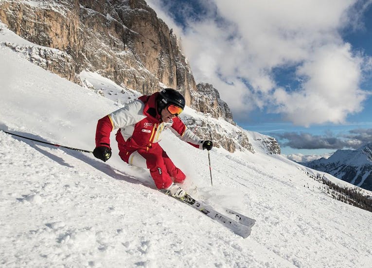 Un maestro di sci della Carezza Skischool scia per primo durante le Lezioni di sci per adulti - Avanzato.