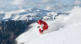 Un maestro di sci della Carezza Skischool dimostra come scendere la pista al meglio durante le Lezioni private di sci per adulti - Tutti i livelli.