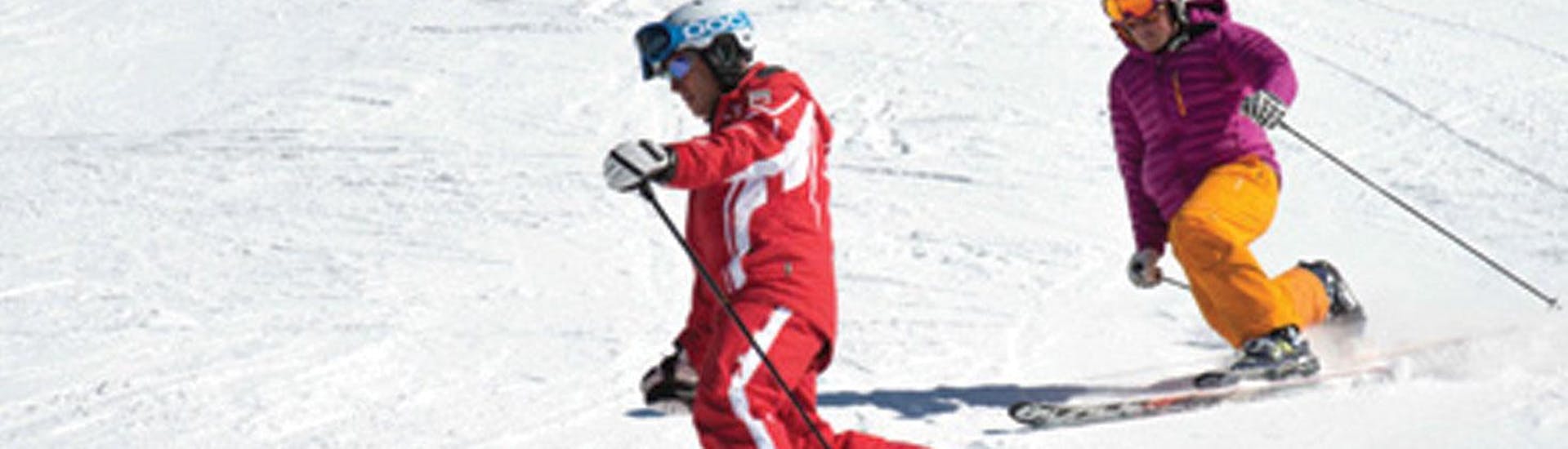 A woman is following her telemark instructor from Carezza Skischool during Private Telemark Skiing Lessons - All Levels.