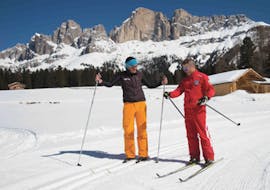 A cross-country skiing instructor from Carezza Skischool is explaining his pupil how to improve the technique during Private Cross Country Skiing Lessons - All Levels.
