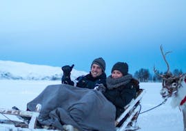 During the Night Reindeer Sledding in Tromsø & Reindeer Feeding, a couple is enjoying a sled ride through a clear arctic night organised by Tromso Arctic Reindeer.