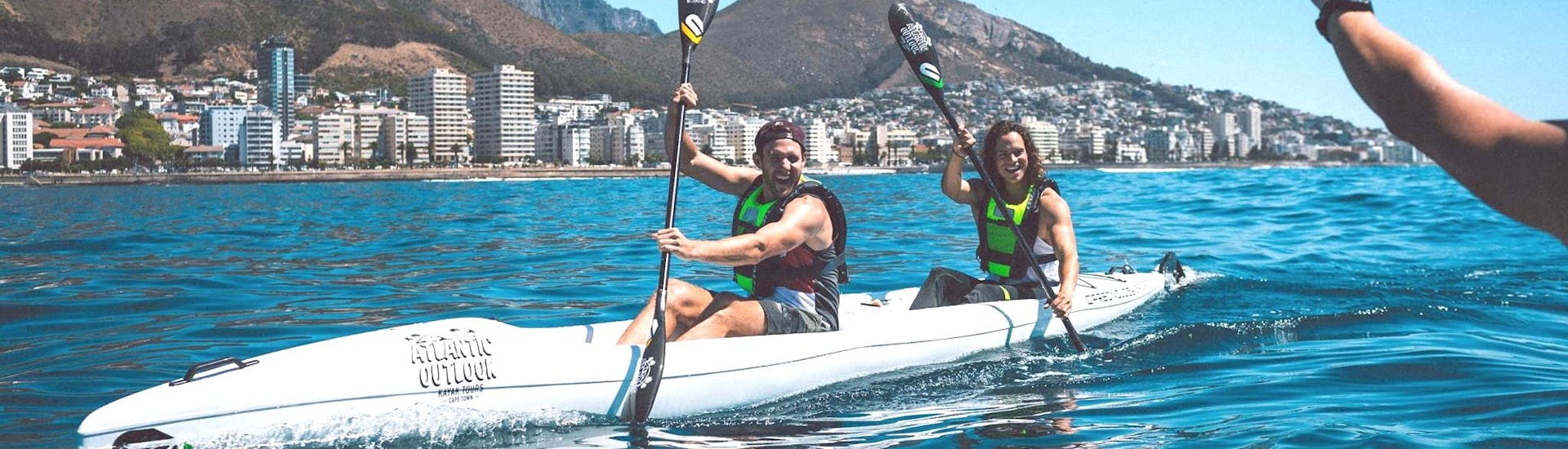 During the Adventure on Sea Kayak in Cape Town, two kayakers are having fun along the Atlantic Sea Board coastline with a their professional kayak guide from Atlantic Outlook.