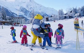 Young skiers are learning to ski with the mascot of the ski school ESF Chamonix during their Kids Ski Lessons "Club Piou-Piou" (3-4 years).
