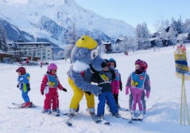 Young skiers are learning to ski with the mascot of the ski school ESF Chamonix during their Kids Ski Lessons "Club Piou-Piou" (3-4 years).