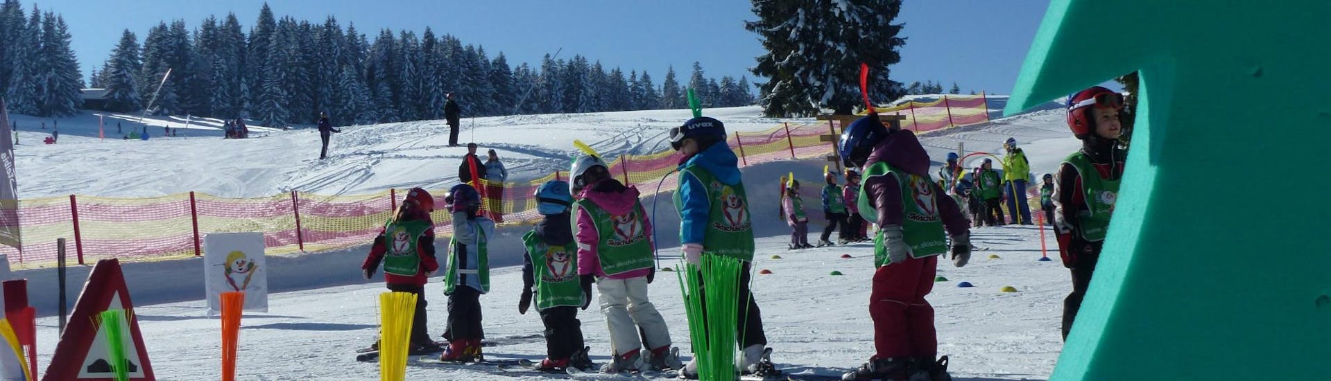 Junge Skifahrer benutzen während ihrem Kinder Skikurs (4-15 Jahre) - Nachmittag - Anfänger mit der Skischule Steibis den Zauberteppich.
