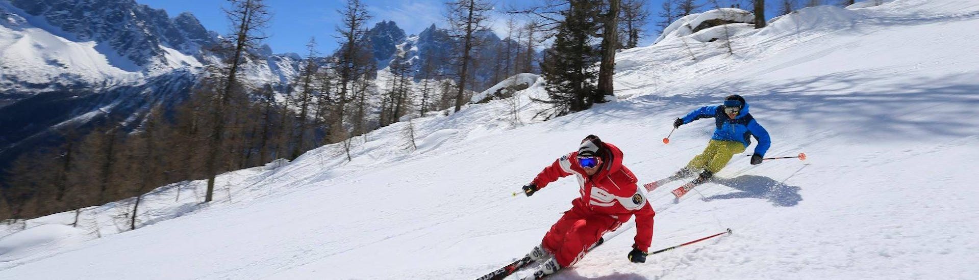 Un skieur suit son moniteur de ski de l'école de ski ESF Chamonix le long d'une pente enneigée pendant son Cours de ski pour Adultes - Tous niveaux.