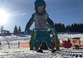 A little boy is taking his first steps on skis during the Private Ski Lessons for Kids - All Levels with Skischule Steibis.