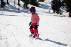 A child is learning to snowboard during Snowboarding Lessons for Kids (8-13 years) - All Levels with the ski school Scuola Nazionale Sci e Snow Monte Pora.