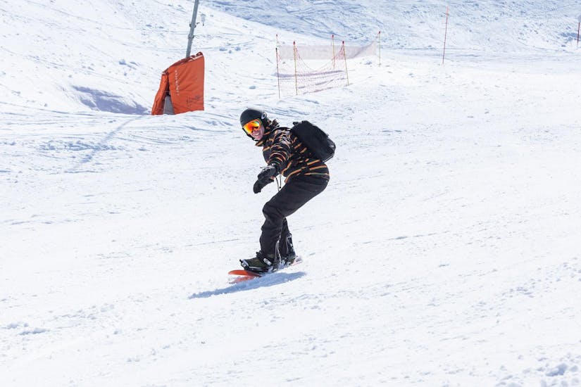Un giovane uomo sta lavorando a migliorare la propria tecnica durante lezioni private di snowboard - Tutte le età e livelli della Scuola Nazionale Sci e Snow Monte Pora.