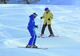 Een ski-instructeur van Skischool Habeler Mayrhofen helpt een student met zijn eerste bocht tijdens de privé skilessen voor volwassenen van alle niveaus.