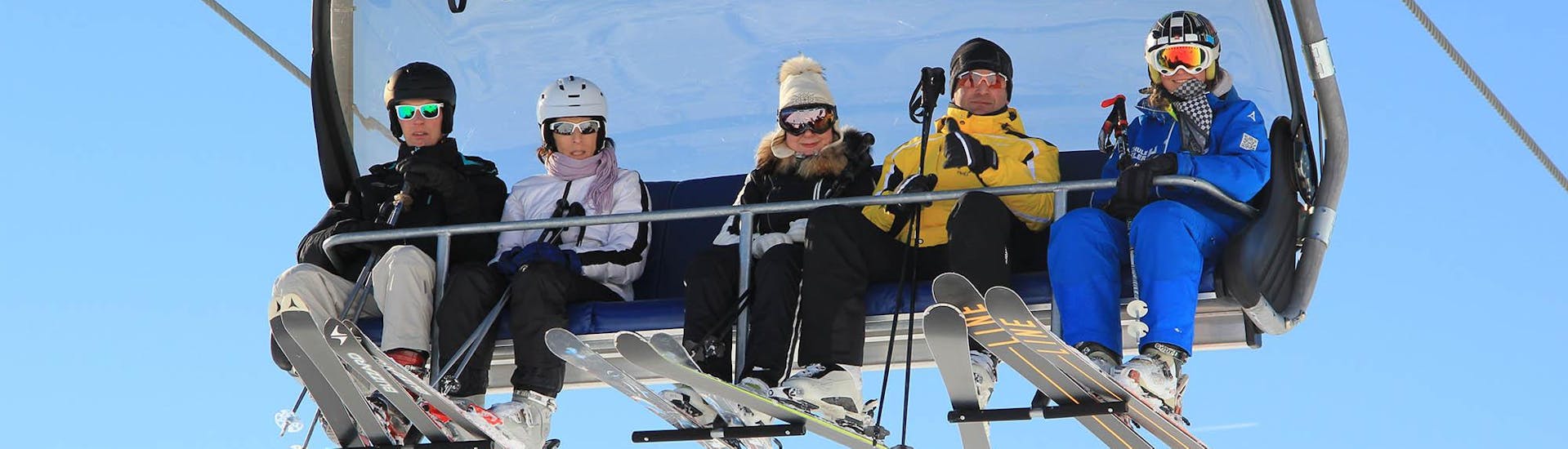 Un grupo de amigos está subiendo al telesilla durante sus clases particulares de esquí para adultos de todos los niveles, con Skischule Habeler Mayrhofen.