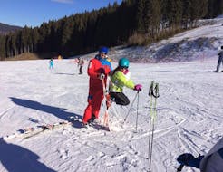 Una giovane sciatrice si sta divertendo sulle piste con il maestro di sci durante una delle Lezioni private di sci per bambini - Tutti i livelli organizzate dalla Scuola di Sci Val Rendena nel comprensorio sciistico di Pinzolo.