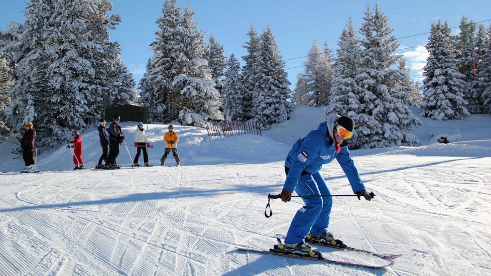 Un moniteur de ski de l'École de ski Habeler - Mayrhofen explique la technique au groupe pendant leurs Premier Cours de ski Adultes "MAX6".