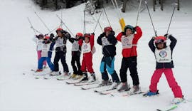 Een groep deelnemers van de kinderskilessen (6-13 j.) - eerste keer georganiseerd door de skischool Scuola di Sci Val Rendena in het skigebied van Pinzolo amuseert zich op de besneeuwde hellingen.