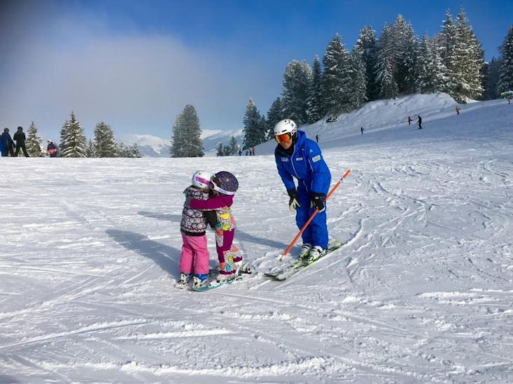 Two little children are having fun during their private ski lessons for kids (from 3 y.) of all levels while they are supervised by their ski instructor from Skischule Habeler Mayrhofen.